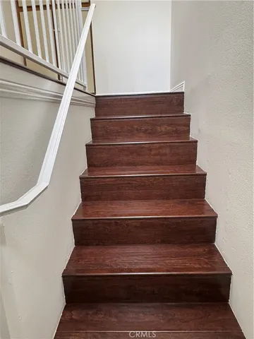 a view of staircase with railing and a window