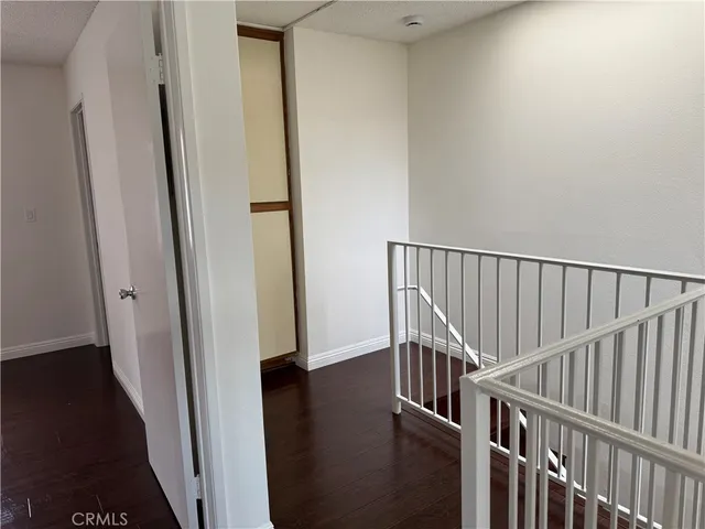 a view of a hallway with wooden floor and closet