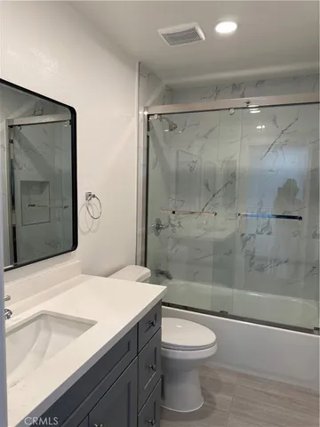 a bathroom with a granite countertop sink toilet and shower