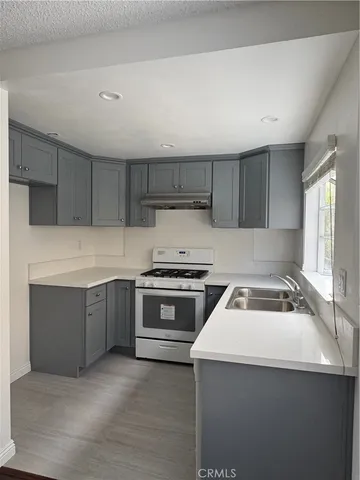 a kitchen with granite countertop a sink and a stove