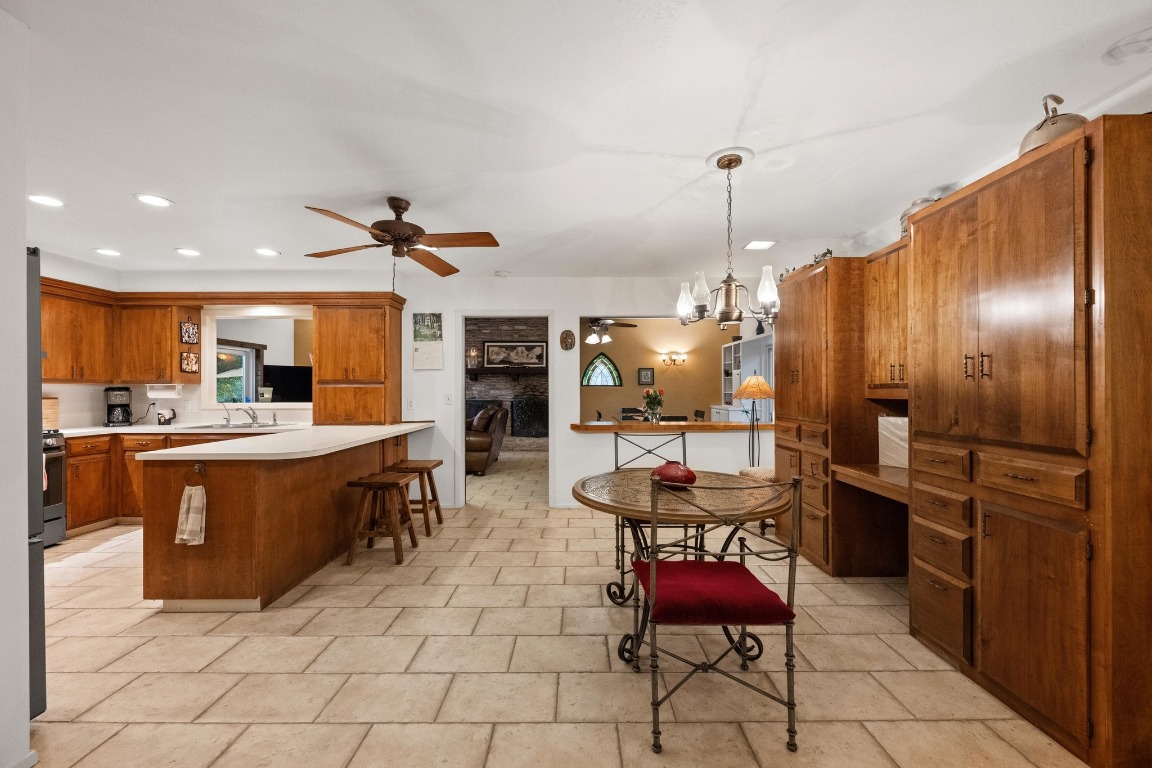 5200 Bell Springs Road Dripping Springs, TX 78620 - Photo 26 of 36 a kitchen with stainless steel appliances kitchen island granite countertop a refrigerator and chairs