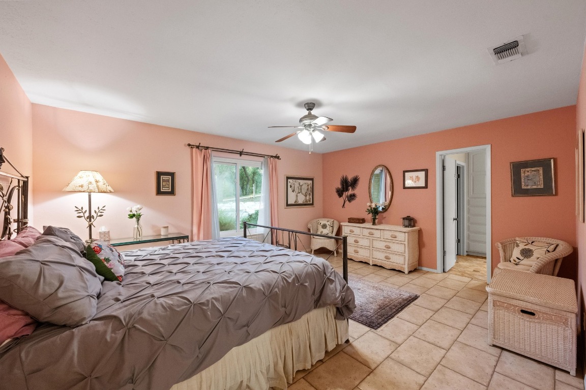 5200 Bell Springs Road Dripping Springs, TX 78620 - Photo 27 of 36 a bedroom with a large bed and a chandelier