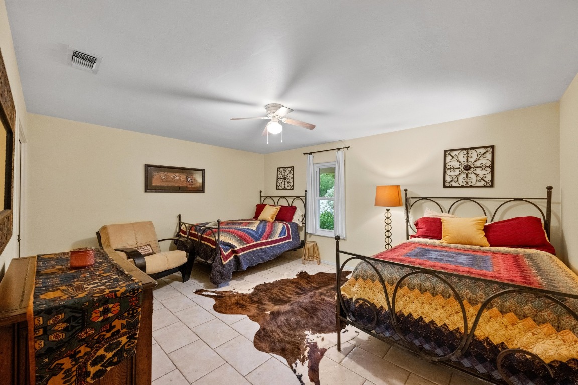 5200 Bell Springs Road Dripping Springs, TX 78620 - Photo 31 of 36 a bedroom with a bed and wooden floor