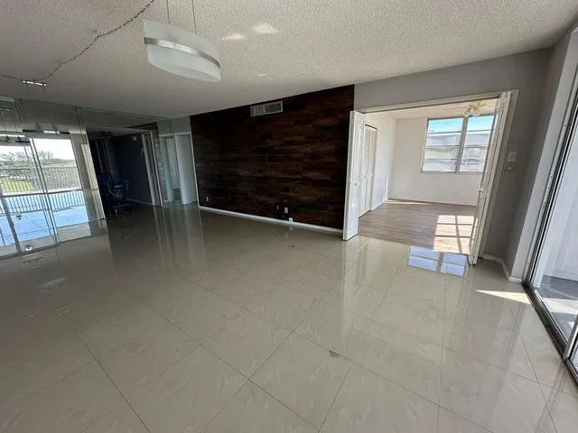 a view of an empty room with a fireplace and a window