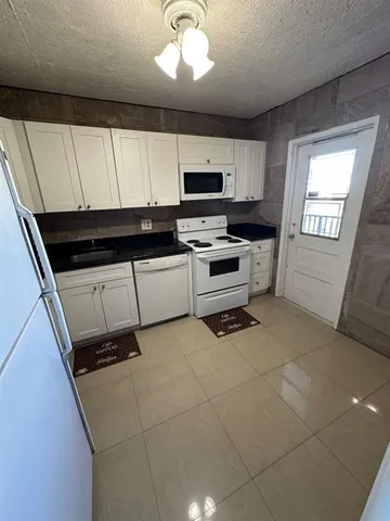 a kitchen with microwave a stove and cabinets