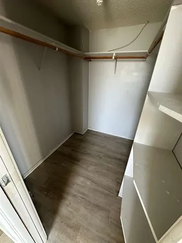 a view of walk in closet with wooden floor