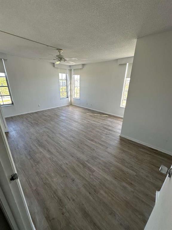 2681 South Course Drive, Unit 612 Pompano Beach, FL 33069 - Photo 10 of 27 an empty room with wooden floor and windows