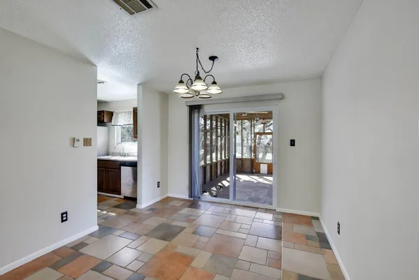 a view of a big room with windows and chandelier fan