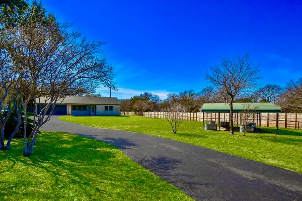 a view of a house with a small yard and tree s