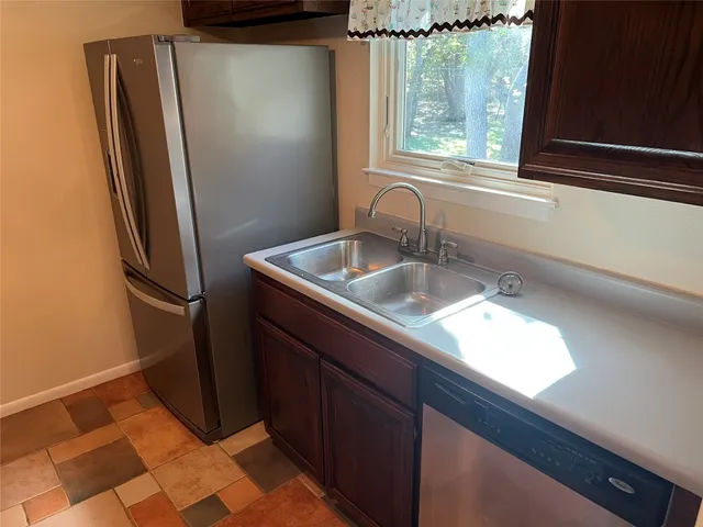 a kitchen with a sink a refrigerator and window