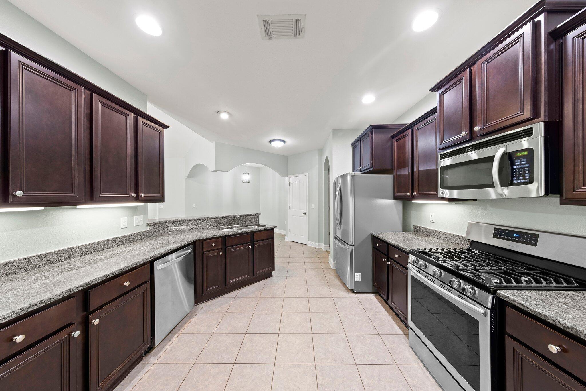 208 Foxchase Way Crestview, FL 32536 - Photo 17 of 51 a large kitchen with stainless steel appliances granite countertop a sink and stove top oven