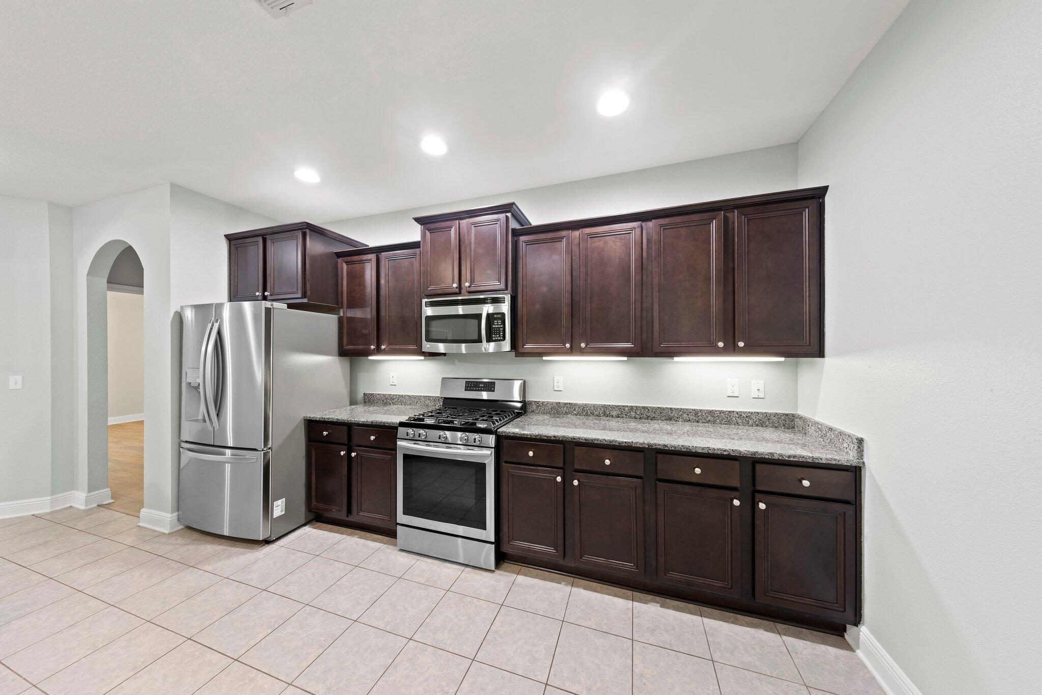 208 Foxchase Way Crestview, FL 32536 - Photo 18 of 51 a kitchen with stainless steel appliances granite countertop a stove top oven a refrigerator and a sink