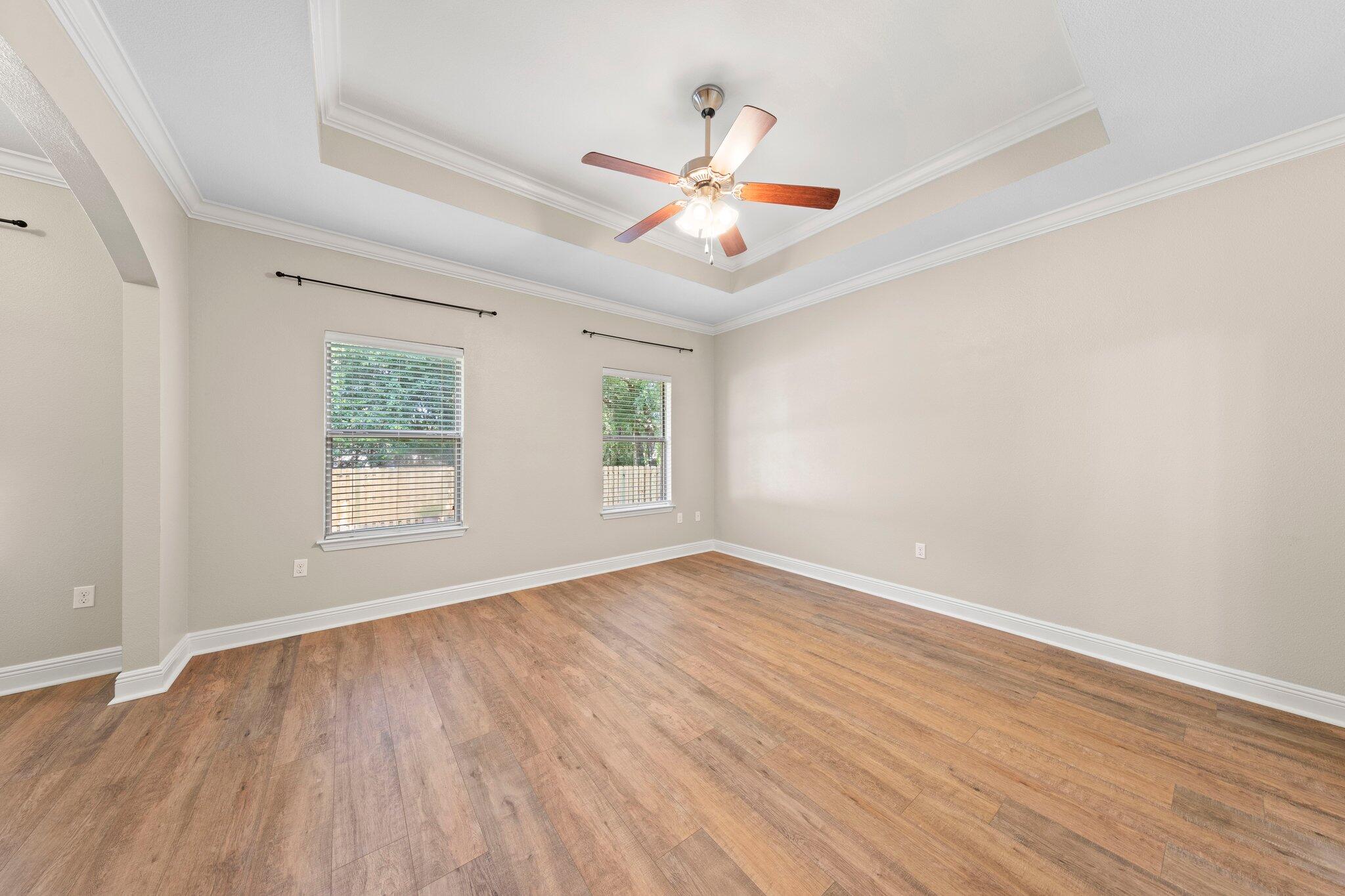 208 Foxchase Way Crestview, FL 32536 - Photo 24 of 51 an empty room with wooden floor ceiling fan and windows