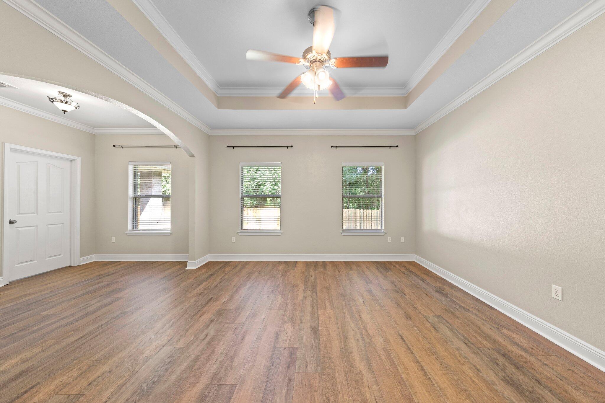 208 Foxchase Way Crestview, FL 32536 - Photo 25 of 51 an empty room with wooden floor chandelier fan and windows
