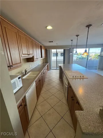 a kitchen with stainless steel appliances granite countertop a sink a stove and a refrigerator