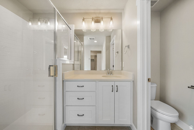 175 West 930 North Santaquin, UT 84655 - Photo 14 of 22 Full bathroom featuring a glass-enclosed shower with white subway tile, a vanity with a light-colored countertop, and a built-in toilet