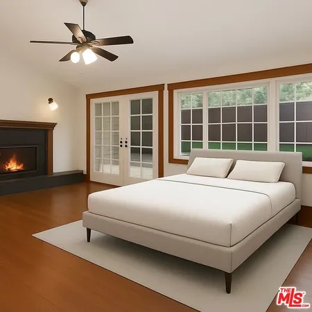 a view of an empty room with wooden floor fireplace and a window
