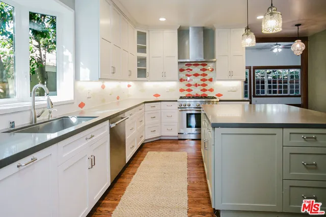 a stove top oven sitting inside of a kitchen