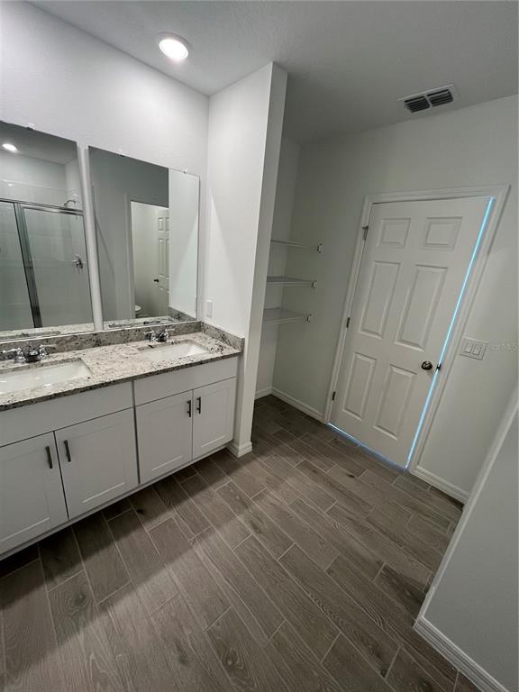 2405 White Tail Street Davenport, FL 33837 - Photo 17 of 24 a spacious bathroom with a double vanity sink and a mirror