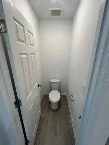 a bathroom with a granite countertop toilet and a sink