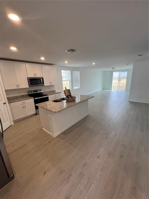 2405 White Tail Street Davenport, FL 33837 - Photo 3 of 24 a kitchen with stainless steel appliances granite countertop a stove a sink and a refrigerator