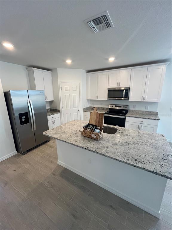 2405 White Tail Street Davenport, FL 33837 - Photo 4 of 24 a kitchen with stainless steel appliances granite countertop a sink refrigerator and microwave