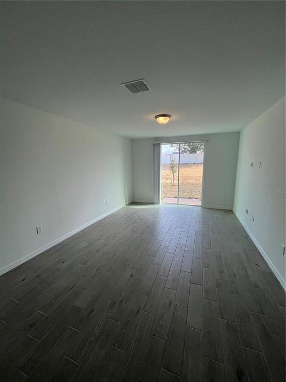 2405 White Tail Street Davenport, FL 33837 - Photo 6 of 24 an empty room with wooden floor and windows