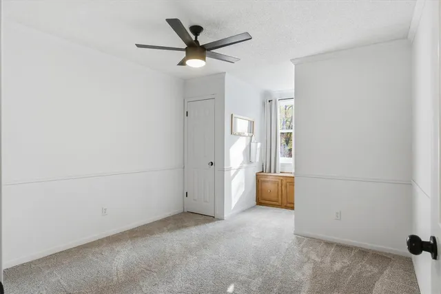 an empty room with closet and windows