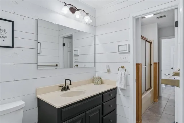 a bathroom with a sink toilet a mirror and shower