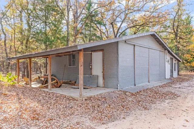 a view of a house with a large tree and wooden fence