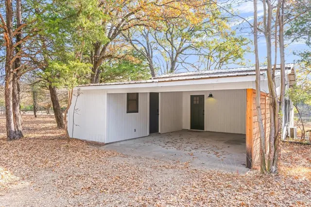 a view of a chair and table in backyard of the house