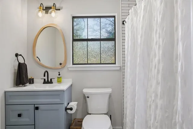 a bedroom with a bed a window and potted plant