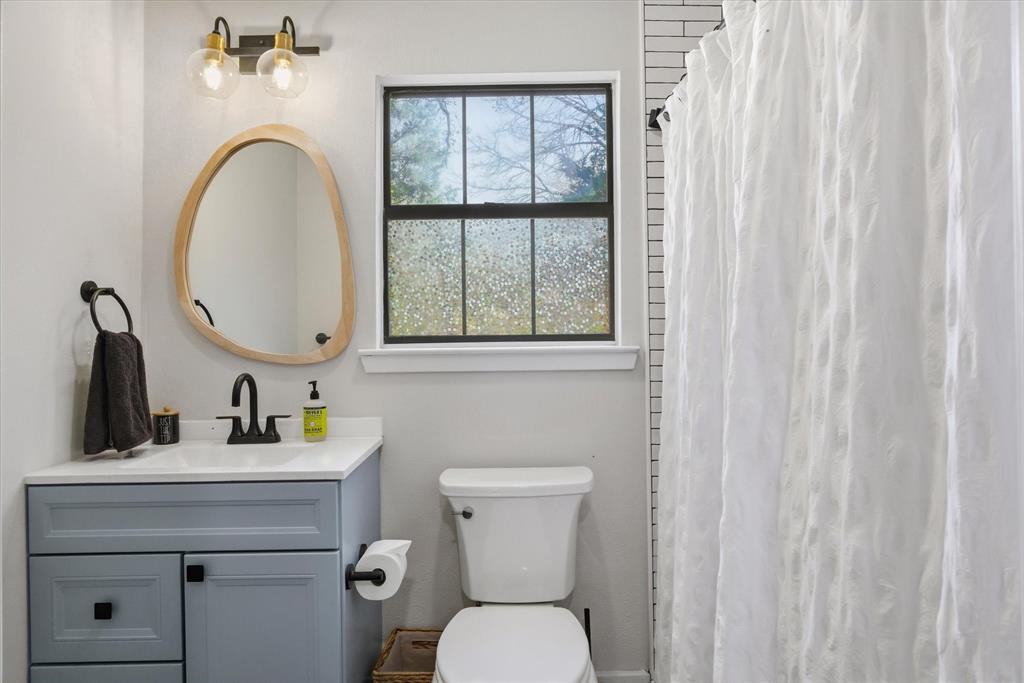 4969 County Road 3502 Wills Point, TX 75169 - Photo 32 of 40 a bathroom with a toilet sink and mirror