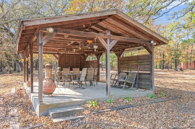 a view of a chairs and table in the patio next to a yard