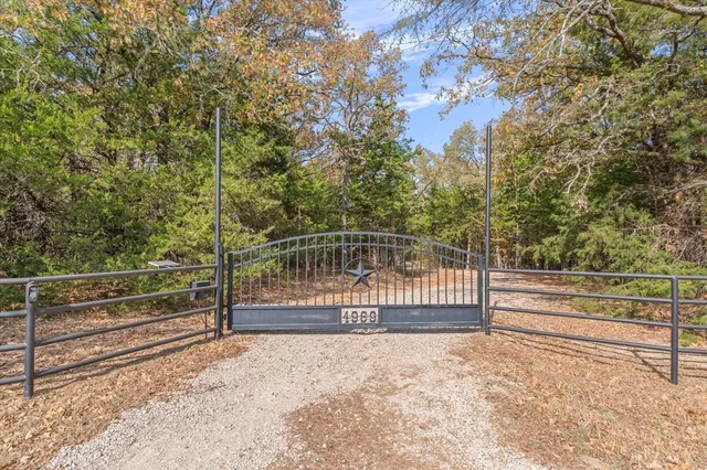 a view of backyard and wooden fence
