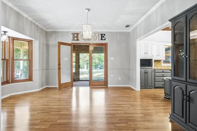 a view of an empty room window and wooden floor
