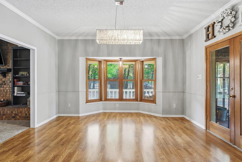 4969 County Road 3502 Wills Point, TX 75169 - Photo 9 of 40 a view of an empty room with wooden floor and a window
