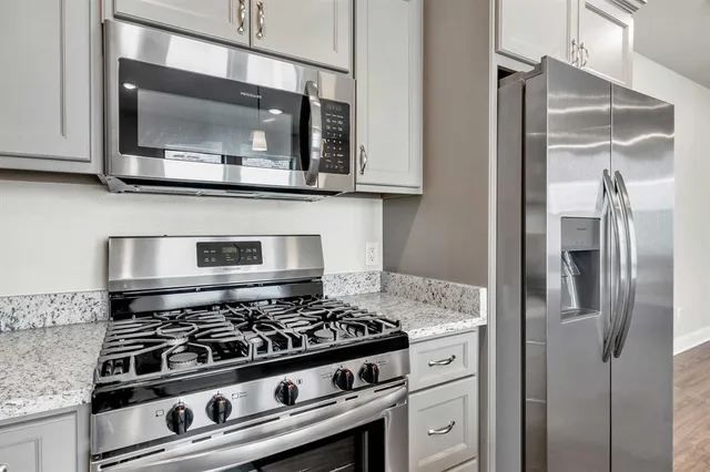 a kitchen with stainless steel appliances granite countertop a stove and a microwave