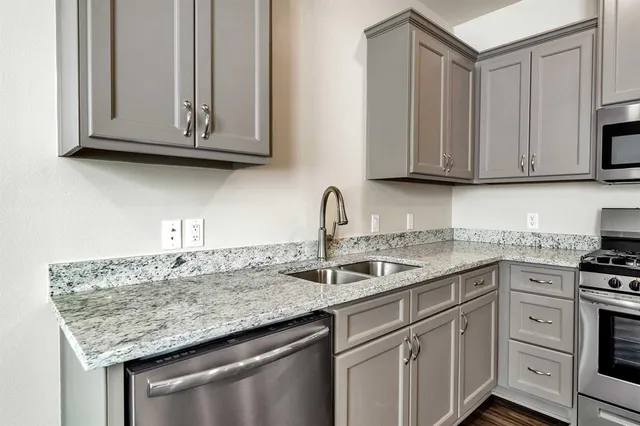 a kitchen with stainless steel appliances granite countertop a sink and cabinets