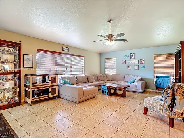 a living room with furniture a flat screen tv and kitchen view