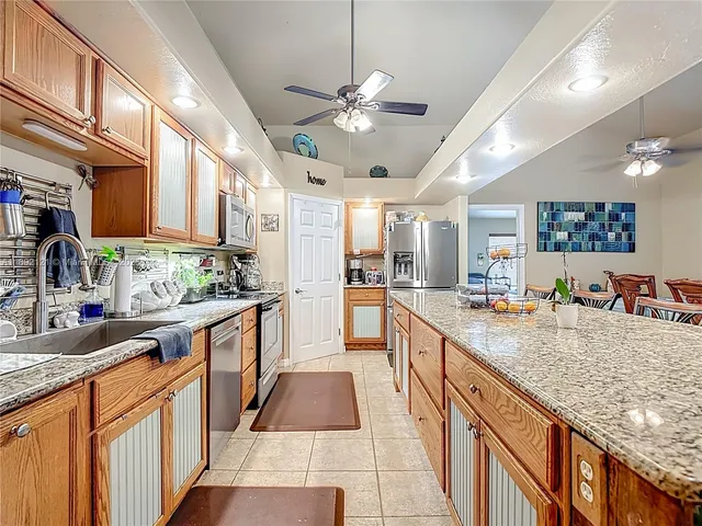 a large kitchen with kitchen island granite countertop a large counter top and stainless steel appliances