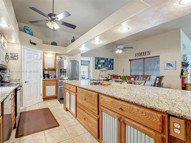 a large kitchen with kitchen island a large counter space a sink stainless steel appliances and cabinets
