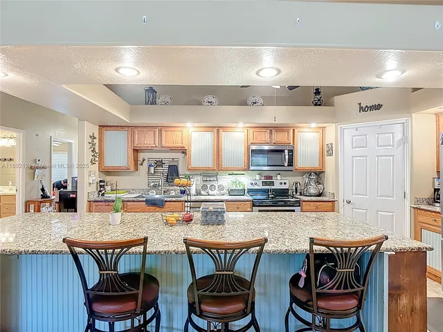 a kitchen with a dining table chairs stove and kitchen view