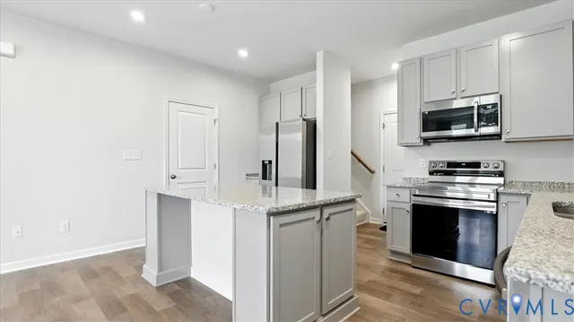 a kitchen with stainless steel appliances a stove microwave and refrigerator