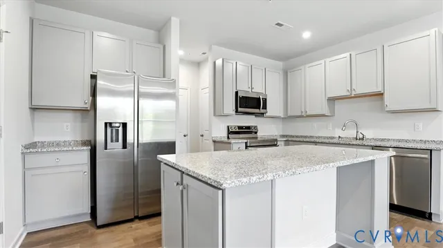 a kitchen with a refrigerator a microwave a sink and cabinets