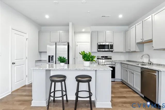 a kitchen with white cabinets a microwave a stove and a refrigerator