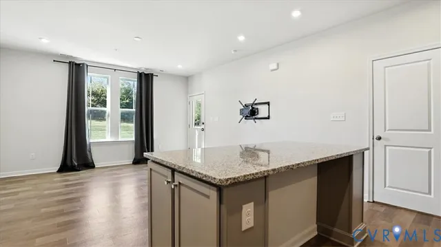 a kitchen with granite countertop a sink and a stove with wooden floor