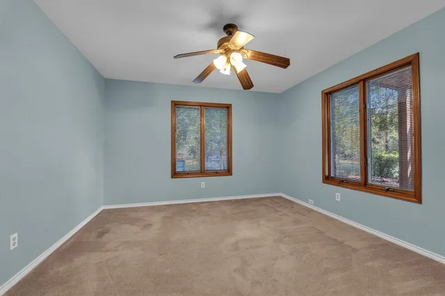 a bathroom with a toilet a sink a mirror and a window