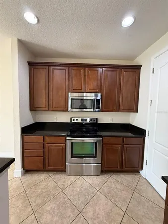 a kitchen with stainless steel appliances granite countertop a stove and a microwave