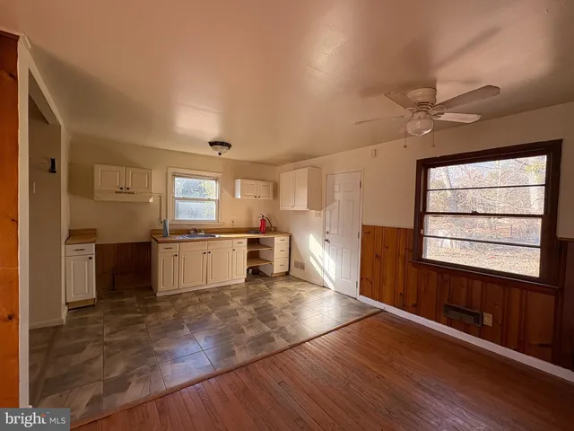 a kitchen with granite countertop a stove cabinets and wooden floor
